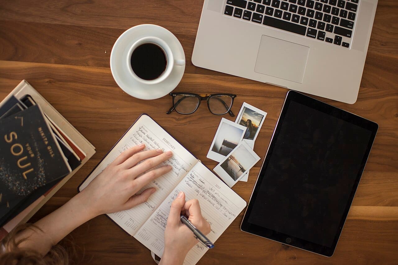 an open journal beside a cup of coffee